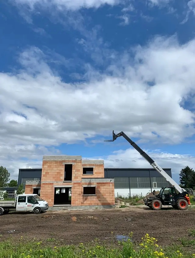 Camion et matériel de chantier BASAK BTP devant une maison en construction