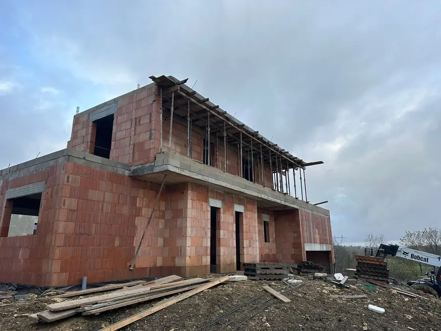 Maison à étage en brique avec plancher et balcon en cours de coffrage