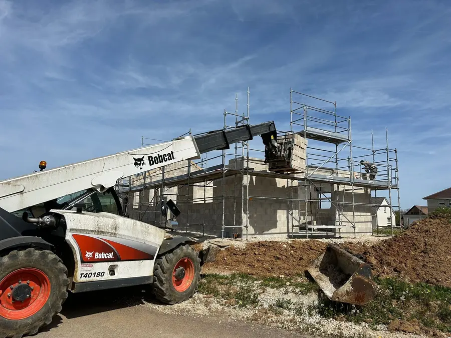 Maison à étage sous échafaudage avec chariot télescopique, chantier de gros œuvre