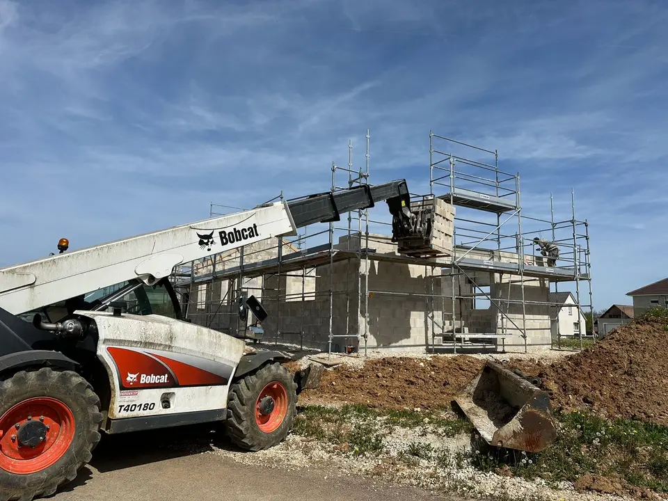 Maison à étage sous échafaudage avec chariot télescopique, chantier de gros œuvre