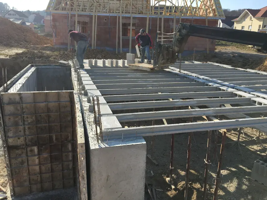 Pose des poutrelles du plancher au-dessus d’un sous-sol par l’équipe BASAK BTP