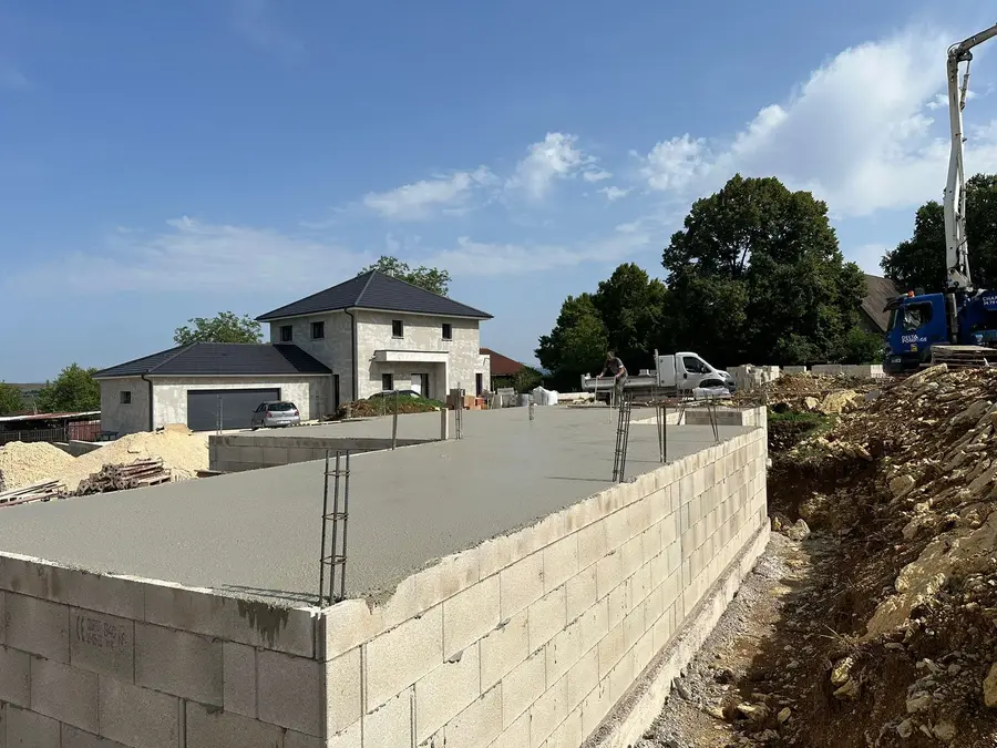 Soubassement en parpaing et dalle béton coulée, pompe à béton sur le chantier
