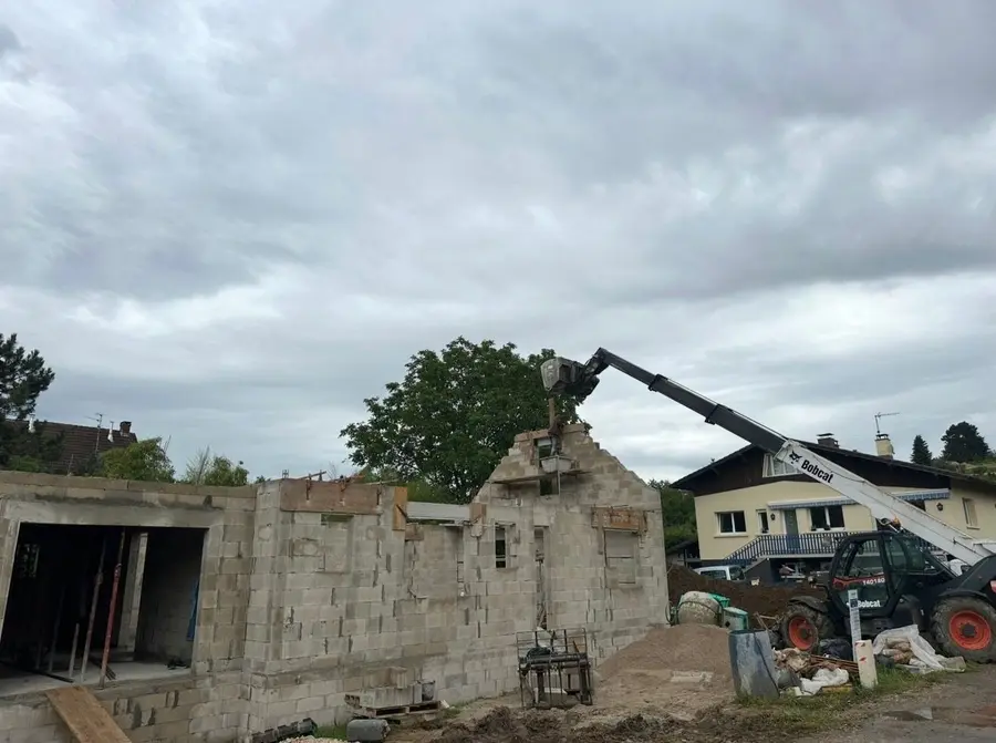 Maison sur sous-sol en parpaing avec pignon monté, chariot télescopique sur le chantier